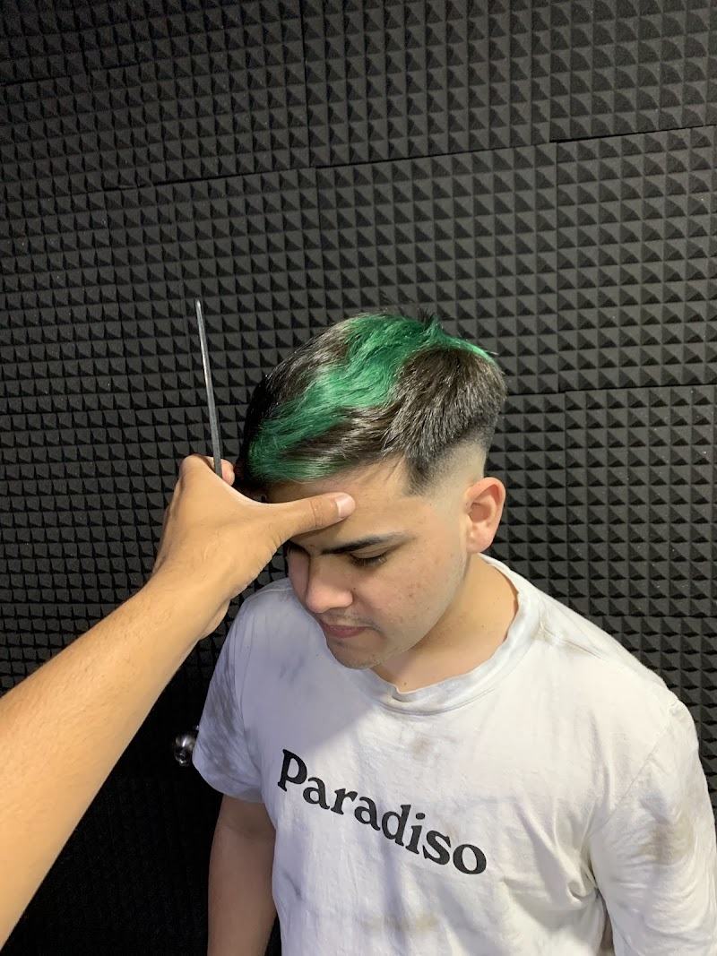 Mechón verde y fade, con la navaja en la mano