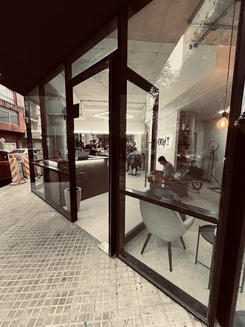 Fachada de GOAT Barbería sobre la calle Brandzen, vidriera abierta y el local iluminado