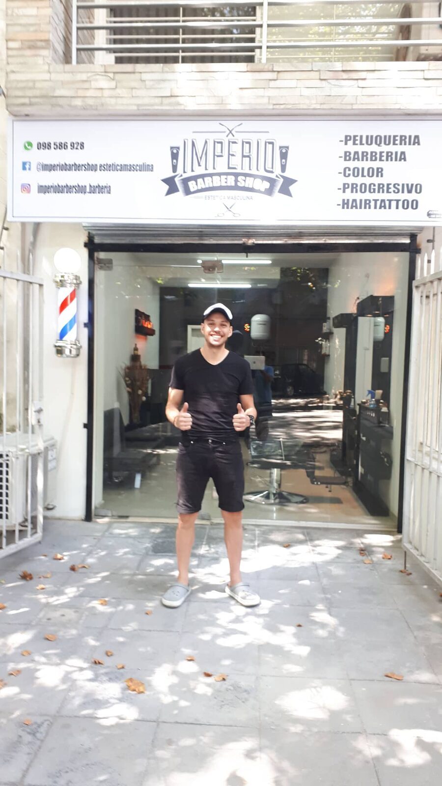 Frente de Imperio Barbershop en Minas 1819: marquesina blanca con el logo, barber pole y la puerta abierta
