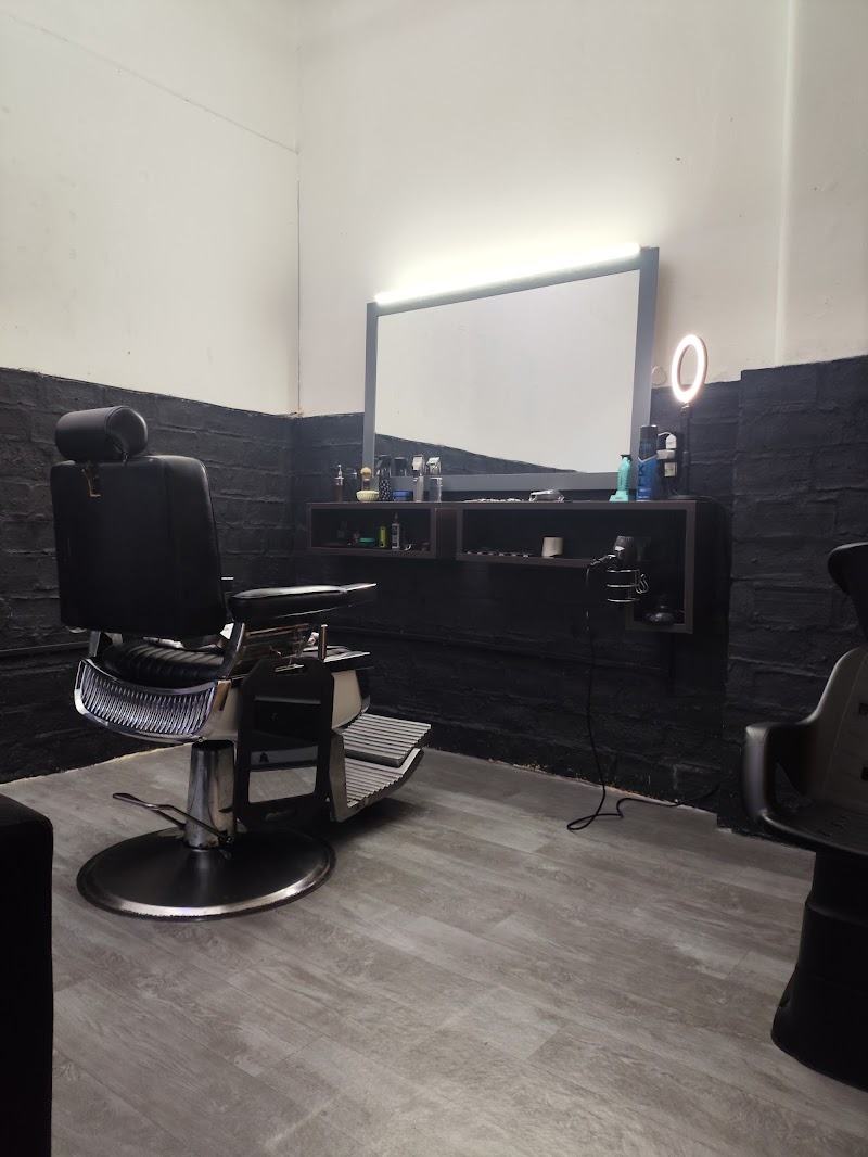 El sillón de barbero frente al espejo con luz, en el local de Guaná 2234