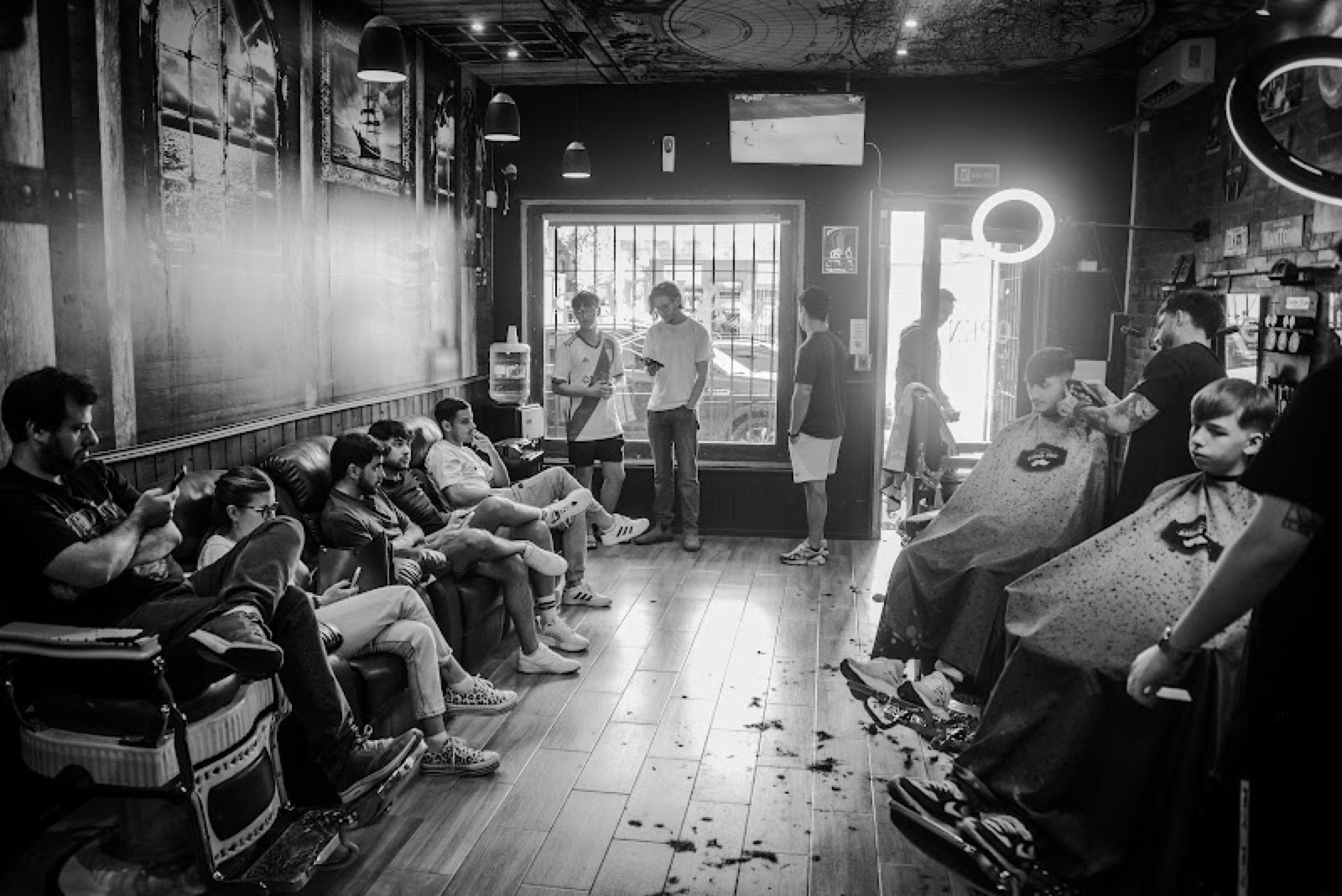 El salón de Barbería Lander lleno: la fila de sillones ocupada y clientes esperando.
