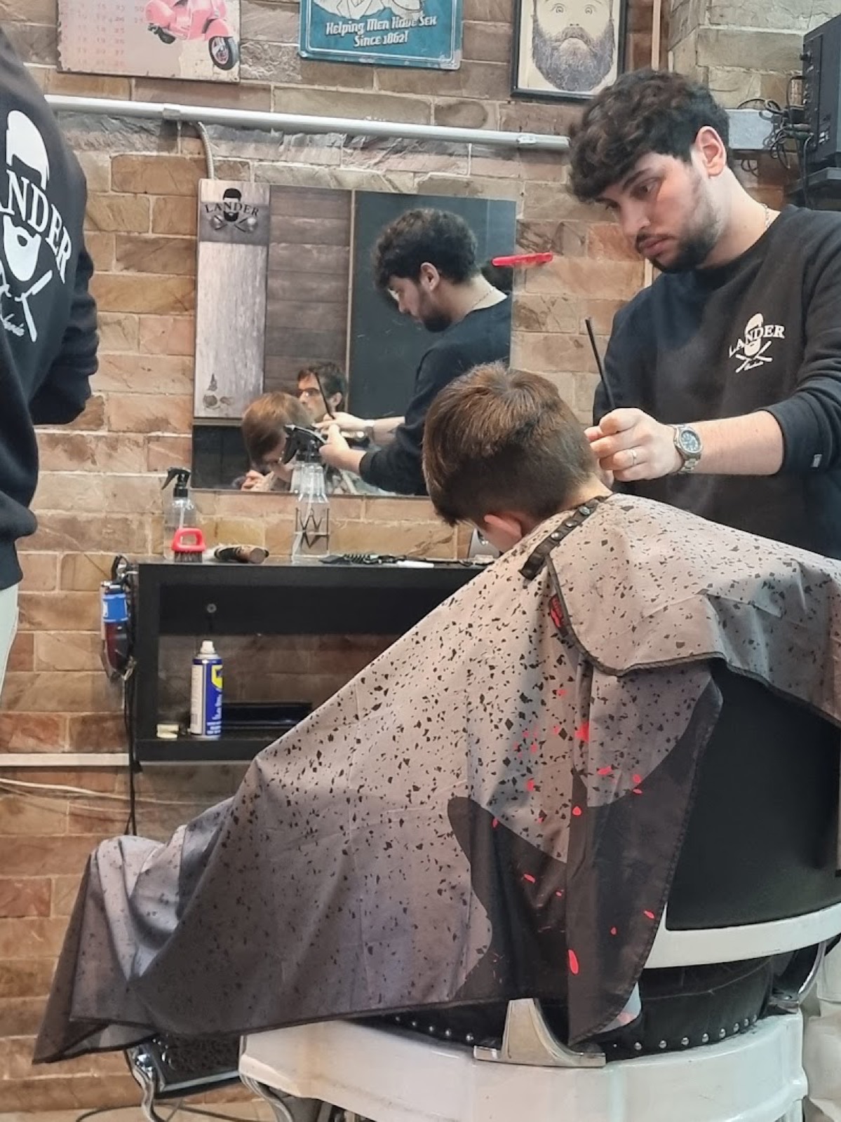 Un barbero de Lander terminando un corte con tijera y peine.