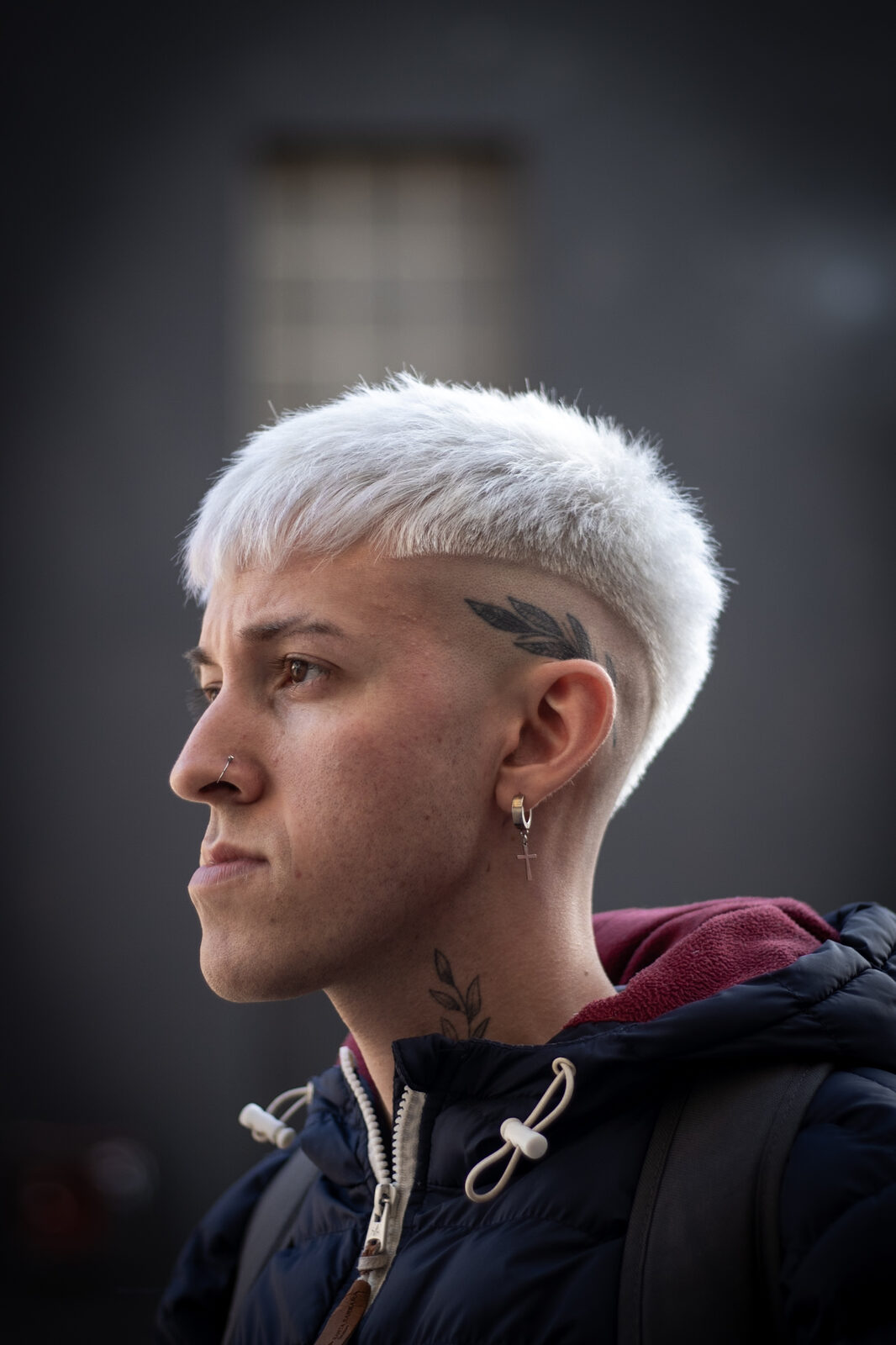 Corte recto platinado, de perfil, con el contorno marcado sobre la oreja