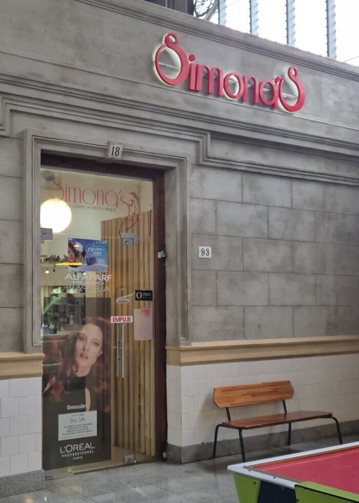 La puerta de Simona's, el número 18, y el cartel rojo corpóreo sobre la pared de piedra