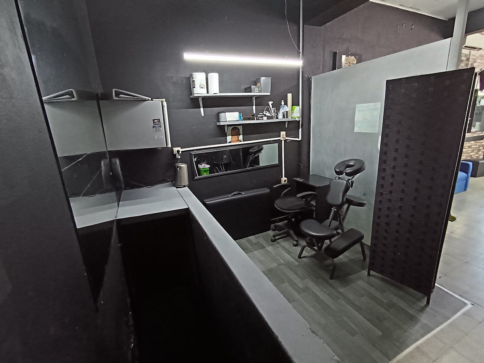 La cabina: sala cerrada con silla de apoyo facial, mesada y biombo