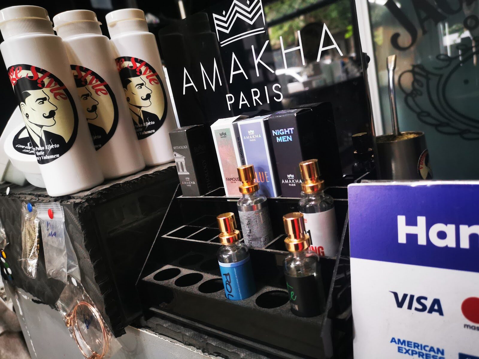 Mostrador con productos de peinado, perfumería y el cartel de tarjetas