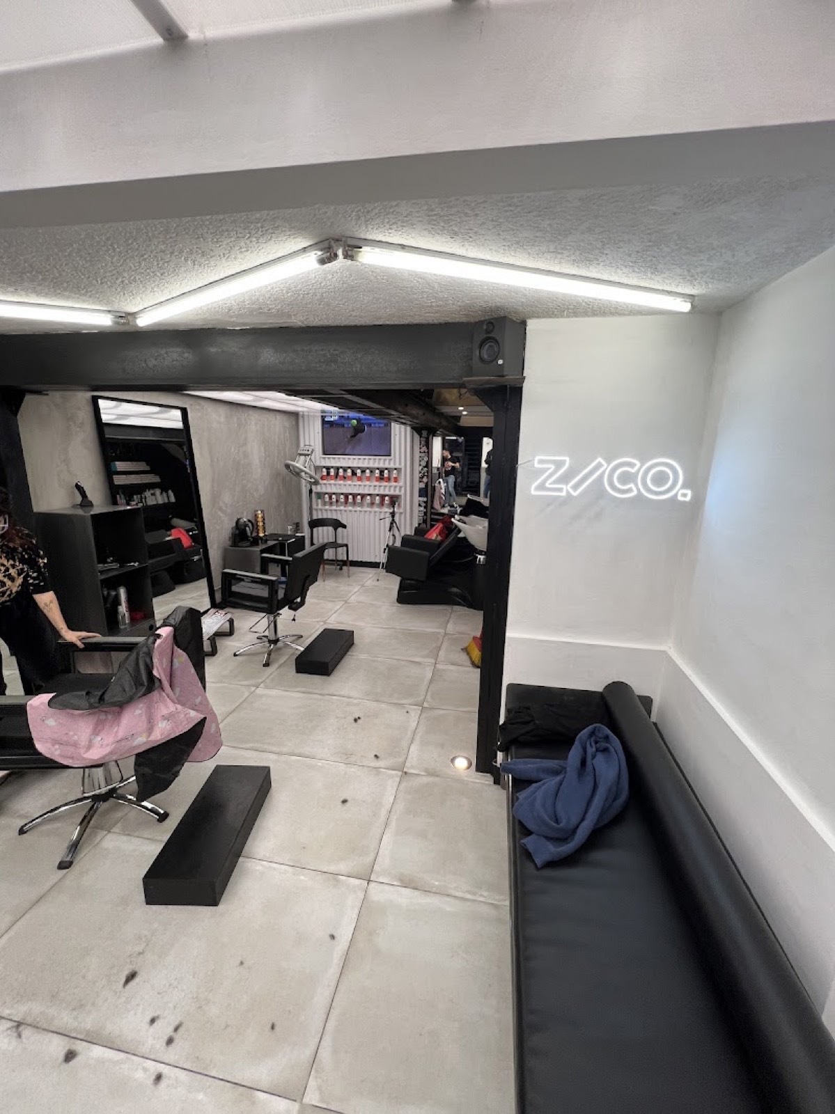 Sala principal de ZACO. con el cartel de neón, el sillón corrido de espera y la luz LED del techo.